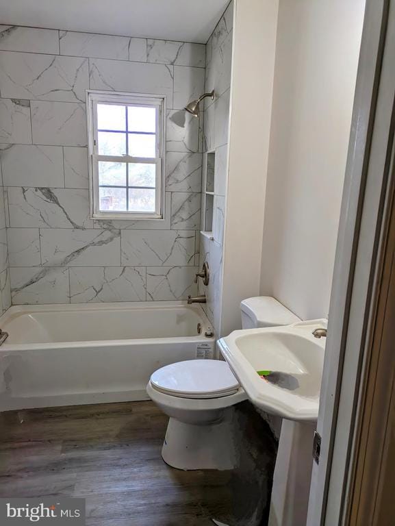 bathroom with toilet, shower / tub combination, and wood finished floors