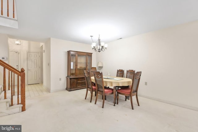 dining area featuring an inviting chandelier and light carpet