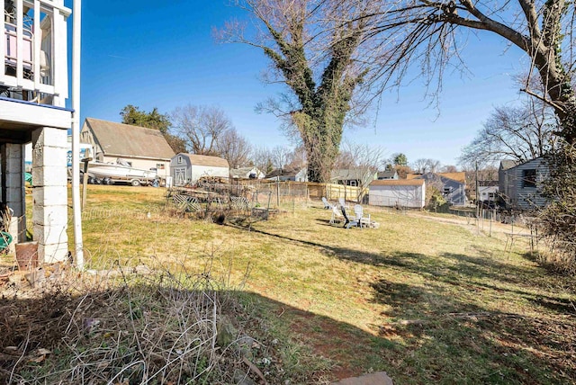 view of yard with an outbuilding, a storage unit, and fence