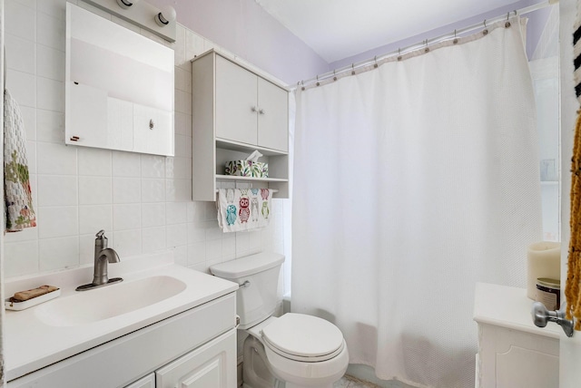 bathroom featuring toilet, vanity, decorative backsplash, shower / bath combination with curtain, and tile walls