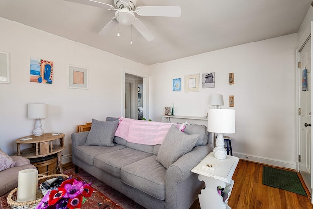 living area with wood finished floors, baseboards, and ceiling fan