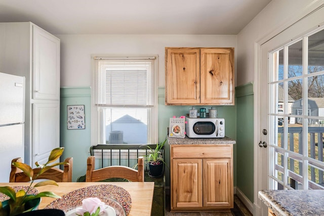 kitchen featuring plenty of natural light and freestanding refrigerator