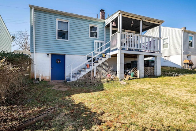 rear view of property with stairs, a yard, and a chimney