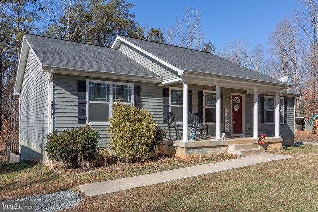 view of front of home with covered porch and a front lawn