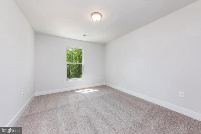 carpeted spare room with baseboards