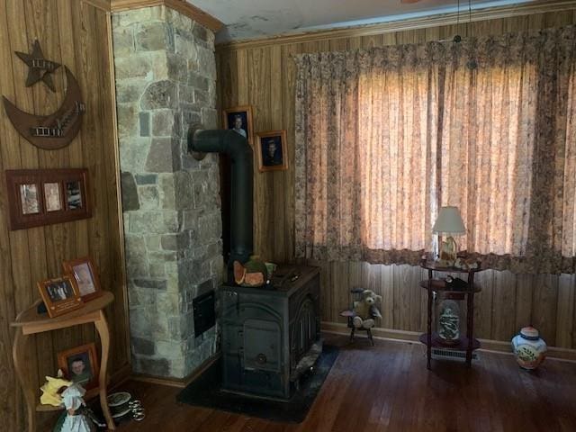 living room featuring a wood stove, wooden walls, and dark hardwood / wood-style flooring