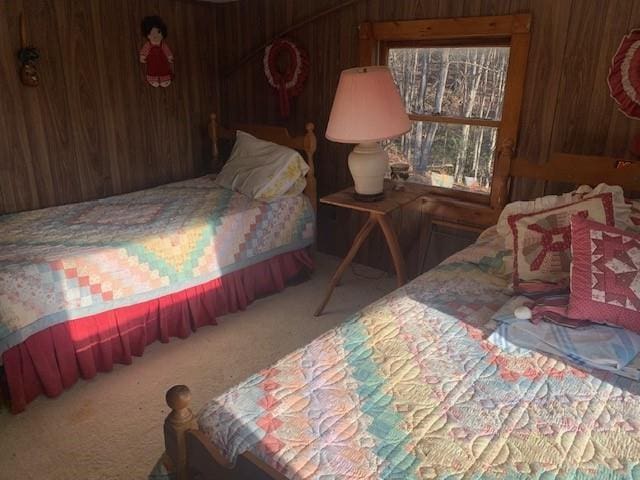 carpeted bedroom featuring wooden walls