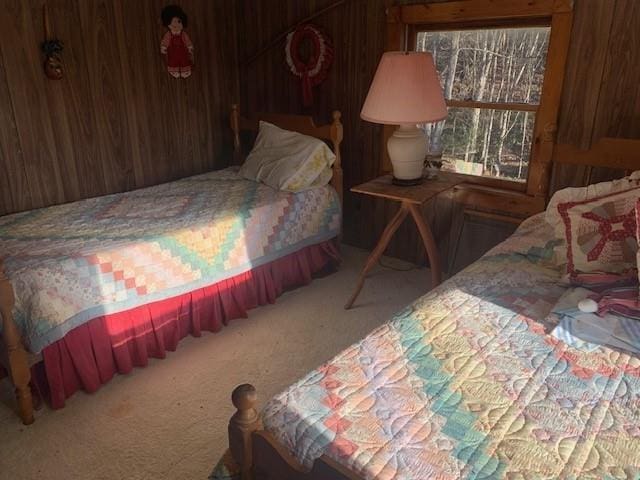 bedroom with wood walls and carpet flooring