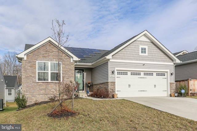 view of front of home featuring cooling unit, a garage, a front lawn, and solar panels