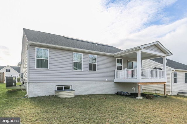 back of house with central AC unit and a lawn