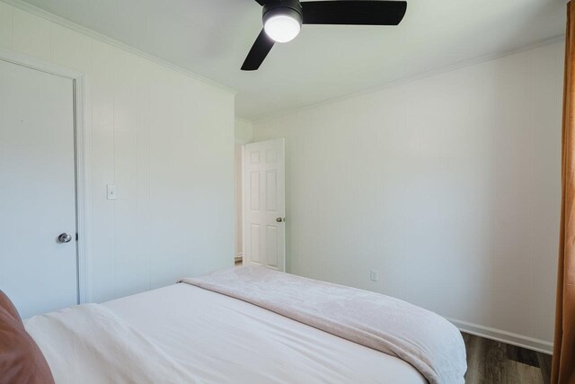 bedroom with crown molding, a ceiling fan, baseboards, and dark wood finished floors