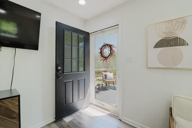 entrance foyer featuring baseboards, ornamental molding, and wood finished floors