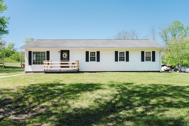 ranch-style house featuring a wooden deck and a front lawn