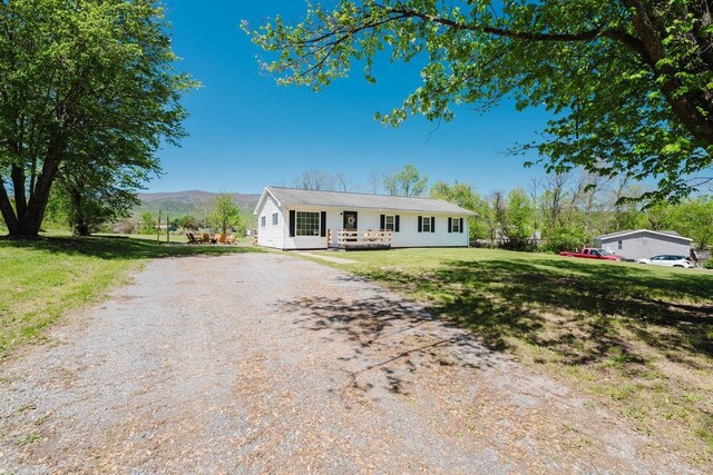 view of front of house featuring a mountain view, a front yard, and dirt driveway