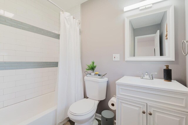 full bathroom with toilet, shower / bath combo with shower curtain, and vanity