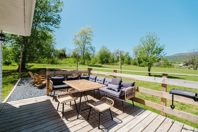 deck featuring a mountain view, a yard, and outdoor dining space