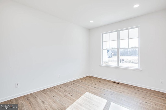 unfurnished room featuring visible vents, recessed lighting, baseboards, and wood finished floors