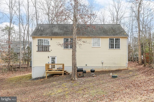 rear view of house featuring a wooden deck