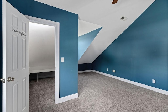 additional living space featuring carpet floors, visible vents, lofted ceiling, baseboards, and ceiling fan