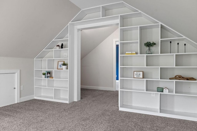 bonus room featuring baseboards, vaulted ceiling, built in shelves, and carpet