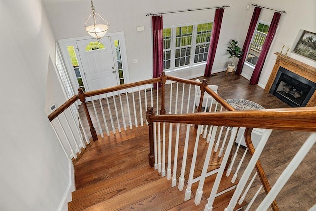 stairs featuring baseboards, wood finished floors, and a fireplace