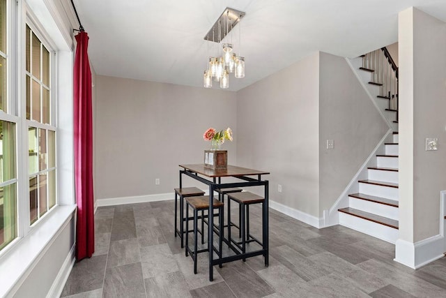 dining space with an inviting chandelier, baseboards, and stairway