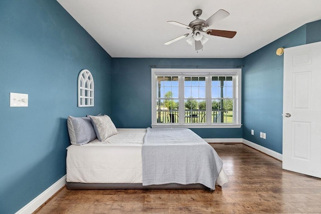bedroom with baseboards, a ceiling fan, wood finished floors, and visible vents