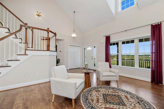 entryway with high vaulted ceiling, stairs, hardwood / wood-style floors, and a wealth of natural light