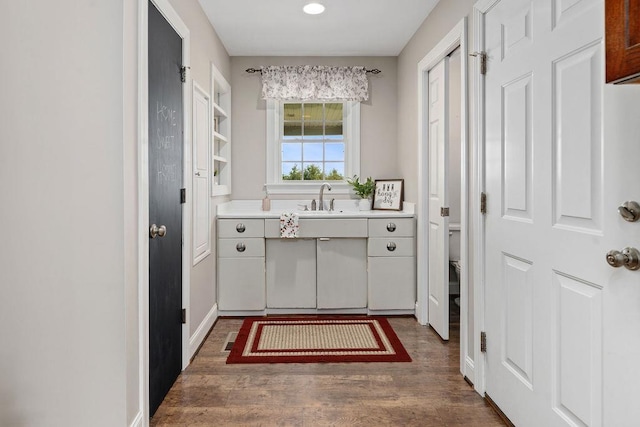 laundry room featuring a sink, recessed lighting, and wood finished floors