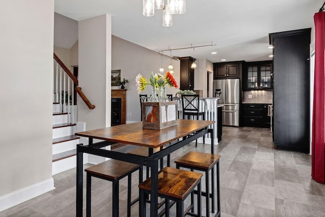 dining space with stairway, baseboards, and an inviting chandelier