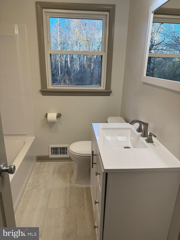 kitchen featuring sink, electric range oven, a textured ceiling, stainless steel fridge, and decorative backsplash