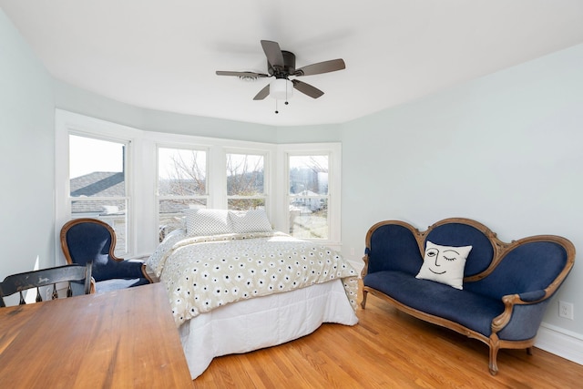 bedroom featuring wood finished floors, baseboards, and ceiling fan