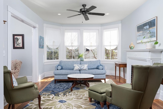 living area with ceiling fan, baseboards, wood finished floors, and recessed lighting