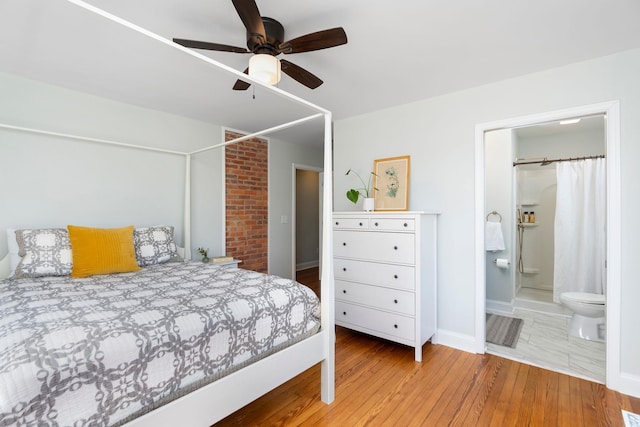 bedroom featuring connected bathroom, wood finished floors, and a ceiling fan