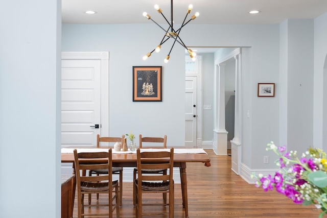 dining space featuring recessed lighting, baseboards, an inviting chandelier, and wood finished floors