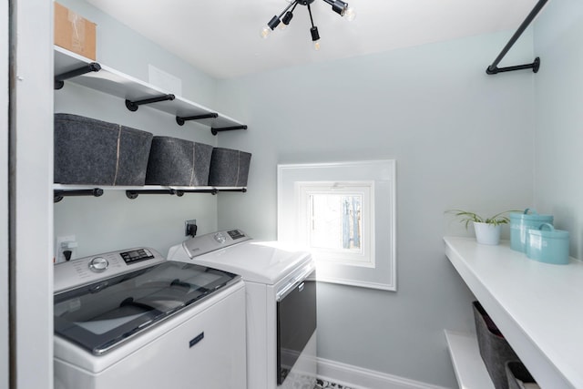 washroom with baseboards, separate washer and dryer, and laundry area