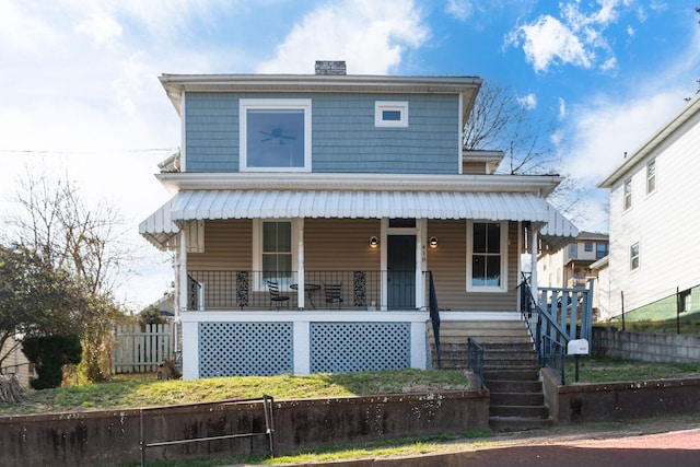 view of front of home featuring a chimney, a porch, stairs, and fence