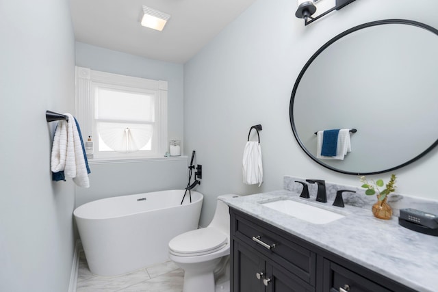 bathroom featuring marble finish floor, a freestanding bath, vanity, and toilet