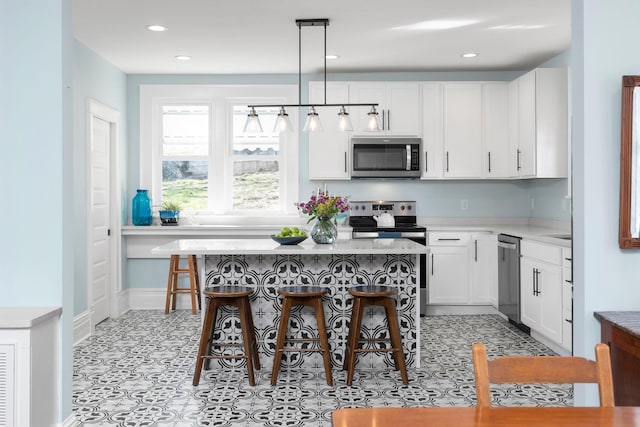 kitchen with a breakfast bar, white cabinets, and stainless steel appliances