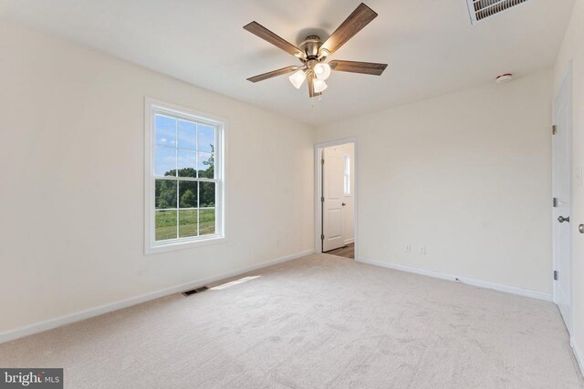 empty room featuring ceiling fan and light colored carpet