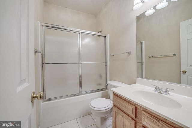 full bathroom featuring tile patterned flooring, vanity, bath / shower combo with glass door, and toilet