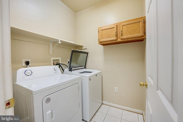 laundry area featuring cabinets, washing machine and dryer, and light tile patterned floors