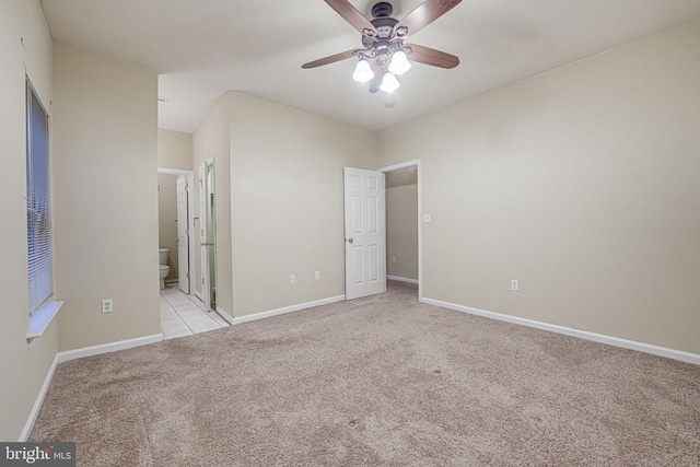 unfurnished bedroom featuring light carpet, ceiling fan, and ensuite bathroom