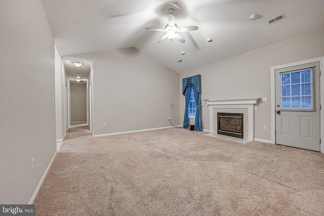 unfurnished living room featuring vaulted ceiling, light colored carpet, ceiling fan, and a fireplace