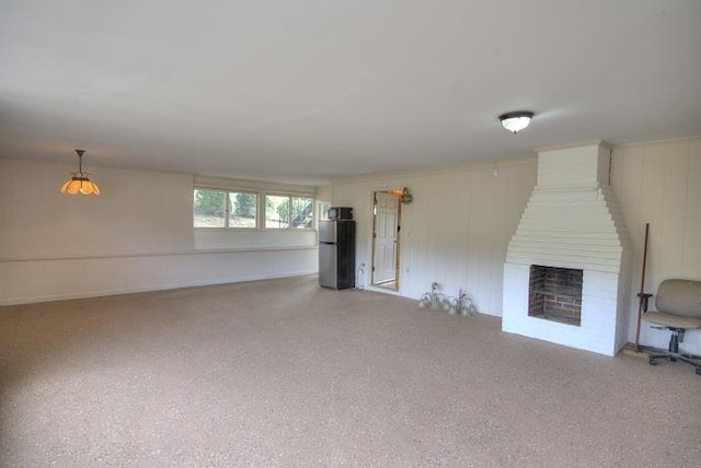 unfurnished living room featuring a brick fireplace and light speckled floor