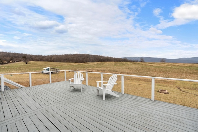 deck featuring a yard, a mountain view, and a rural view