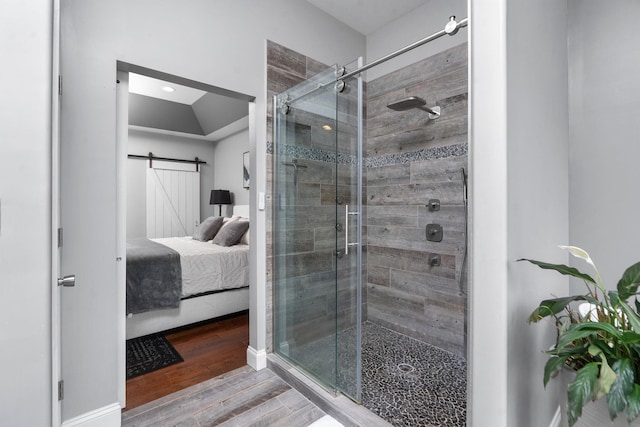 bathroom with hardwood / wood-style floors and a shower with shower door