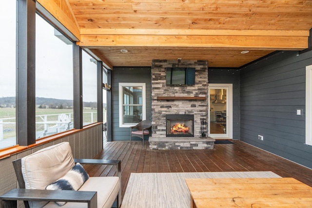 sunroom featuring wood ceiling and an outdoor stone fireplace