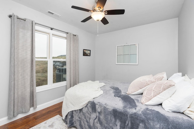 bedroom with dark hardwood / wood-style floors and ceiling fan