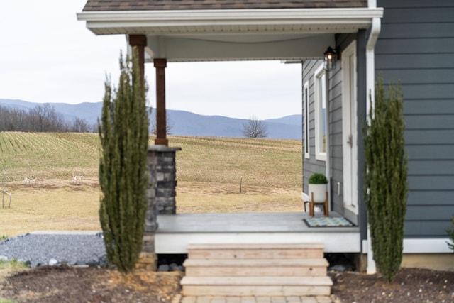 wooden deck with a mountain view, a rural view, and a lawn